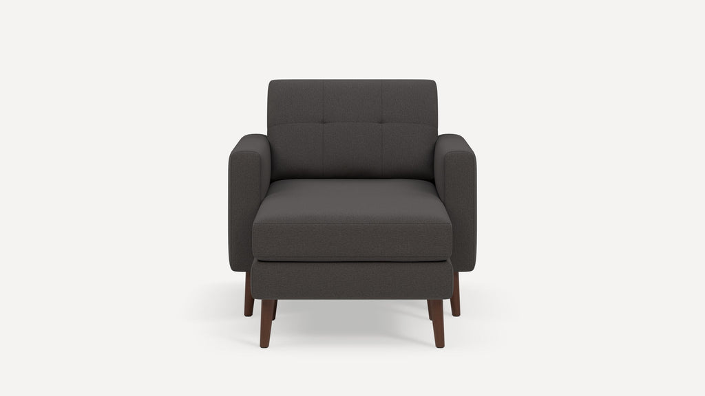 Front view of a modern dark gray upholstered armchair with wooden legs and slightly tufted backrest.