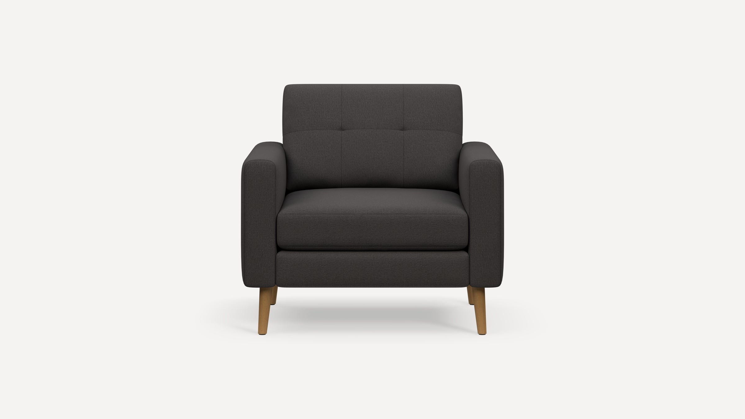 Front view of a modern dark gray upholstered armchair with tufted backrest and wooden legs on white background.
