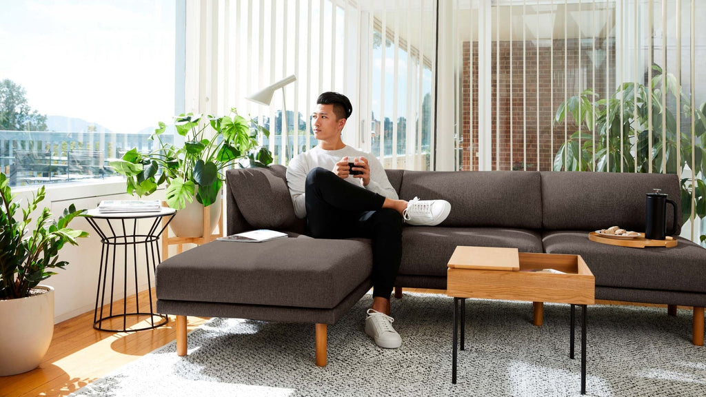 Man sitting on Burrow Range sofa in light airy room with natural light