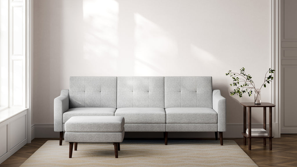 a modern living room with a light gray sofa and matching wooden side tables