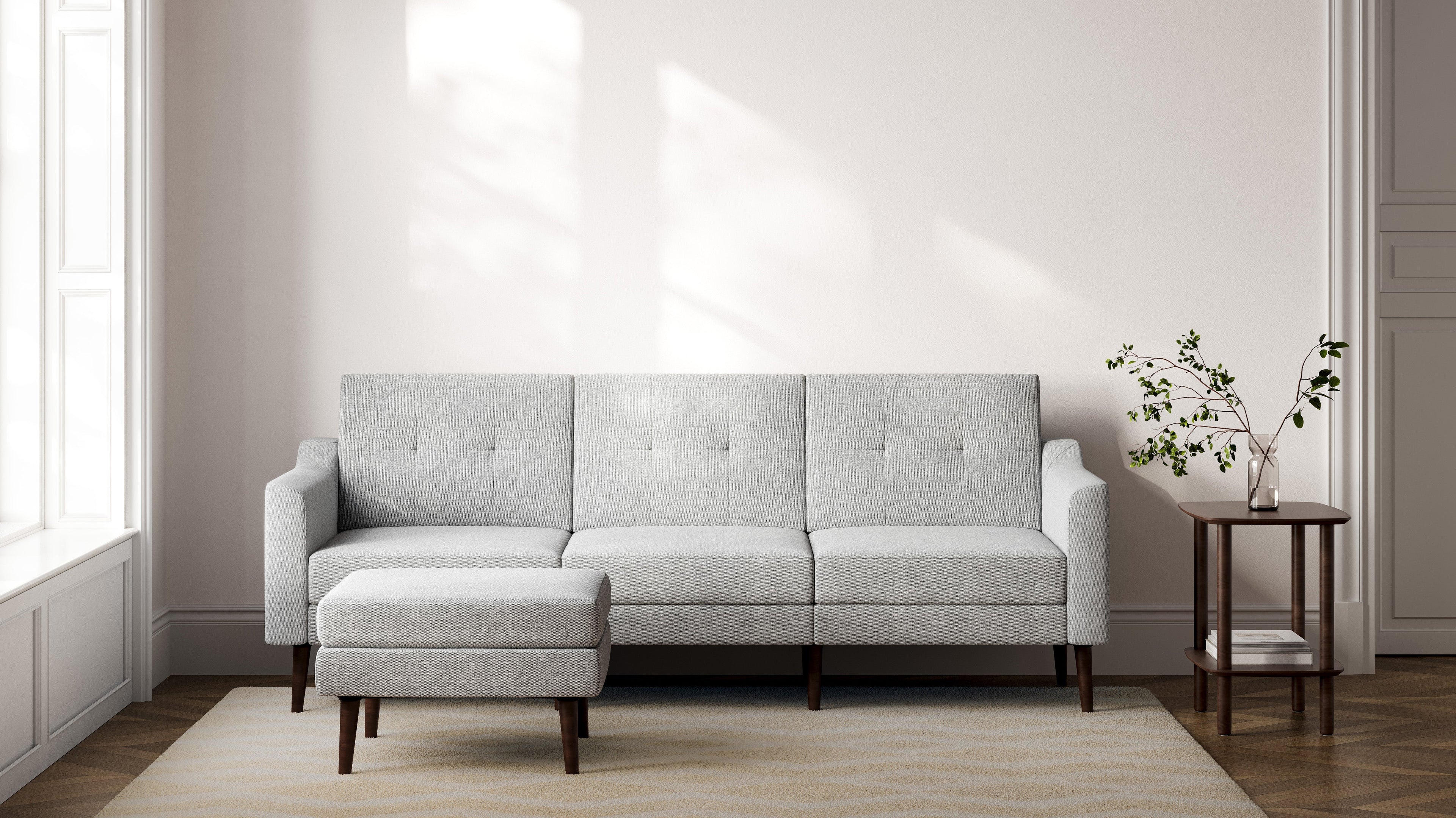 a modern living room with a light gray sofa and matching wooden side tables