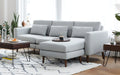 modern light gray sectional sofa with chaise lounge and matching ottoman on white rug in living room