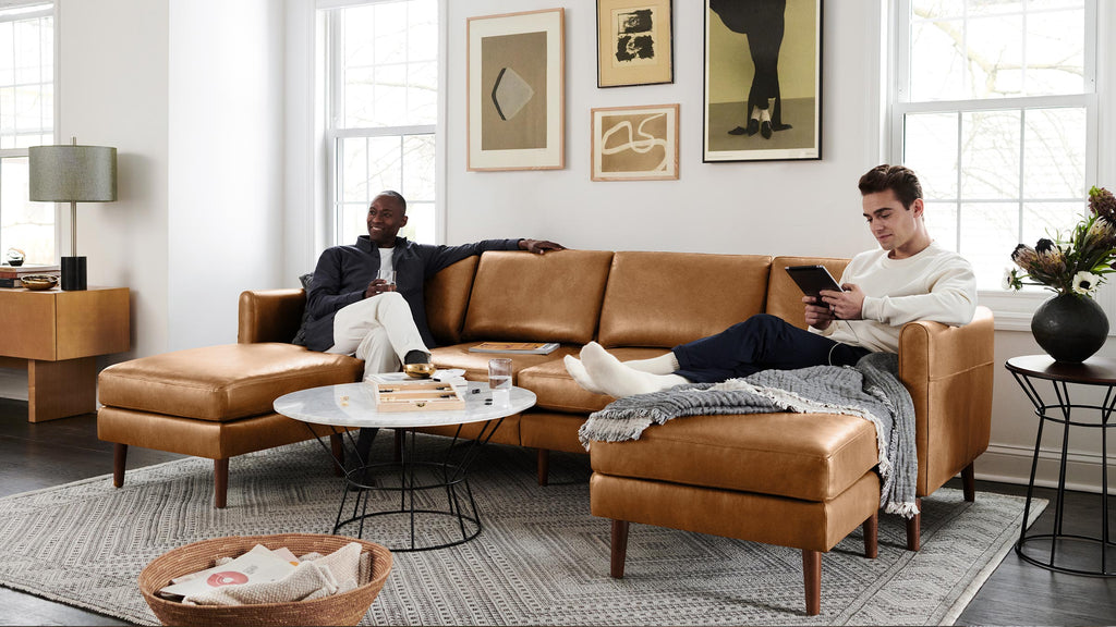 two men lounging on a burrow u_shaped sofa