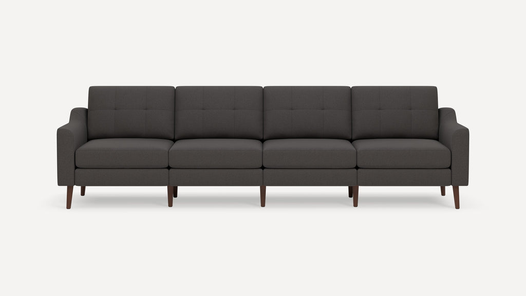 Dark gray four-seater sofa with tufted back cushions, slim arms, and wooden tapered legs, shown against white background.