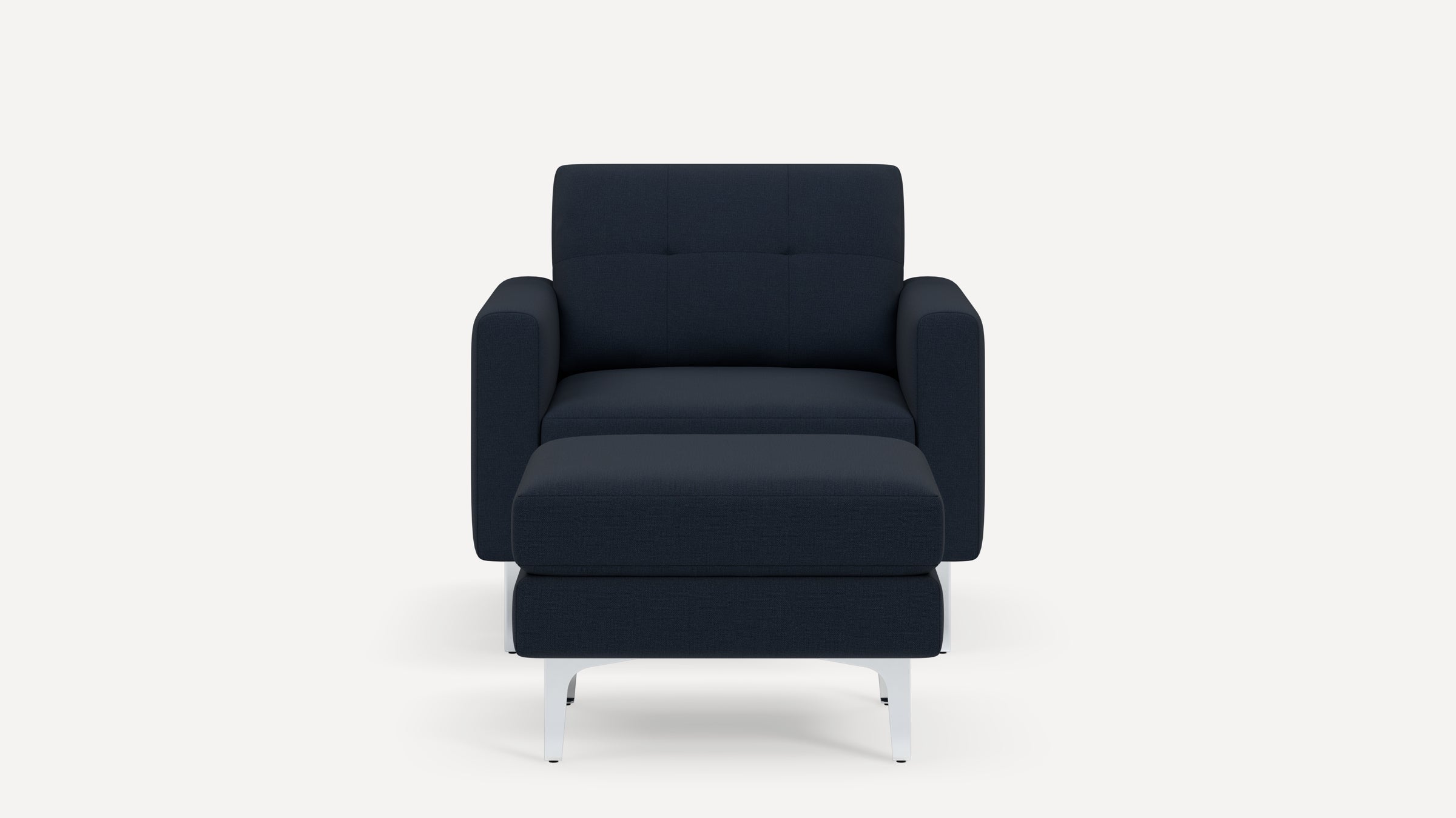 Front view of a modern dark blue upholstered armchair with a matching cushioned ottoman and white metal legs.