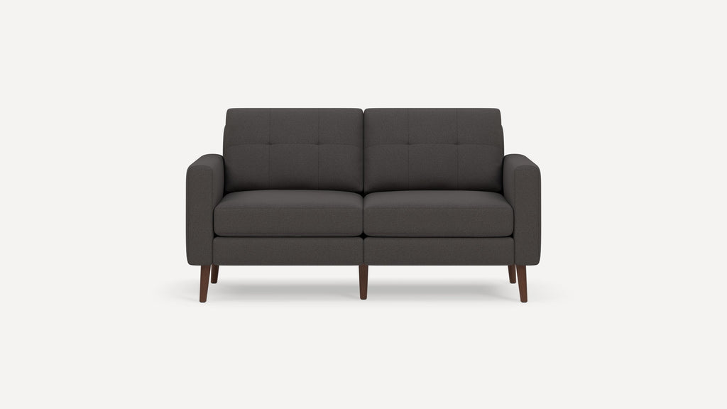 Dark gray modern two-seater sofa with tufted back cushions, rounded armrests, and wooden tapered legs on a white background.