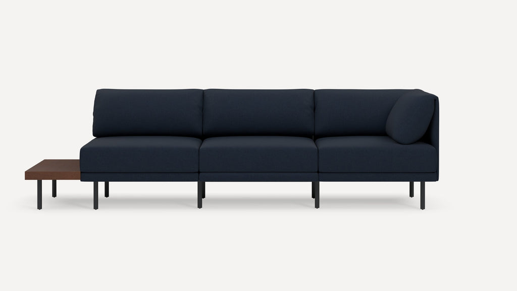 Modern navy blue sectional sofa with three cushion seats, black metal legs, and an attached wooden side table on the left.