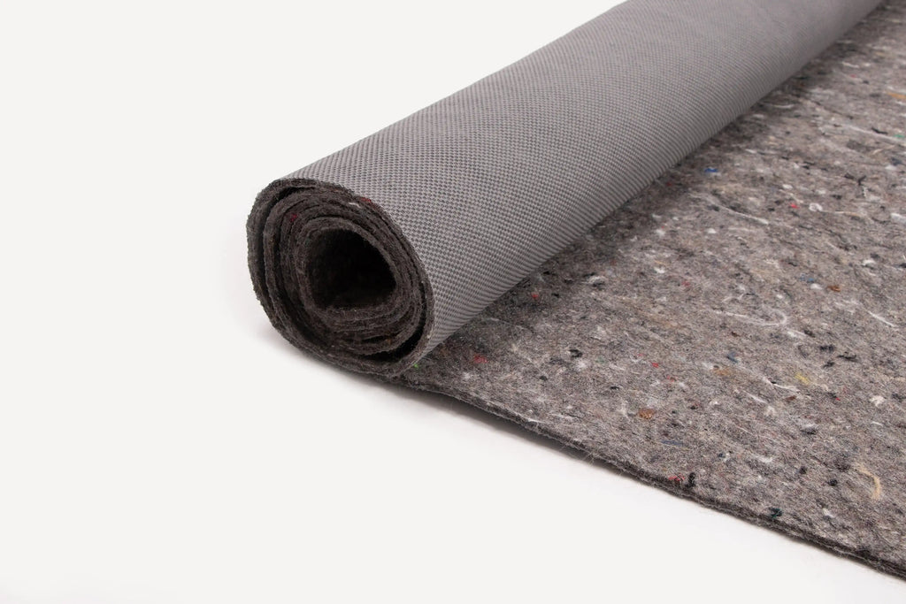Rolled-up gray felt fabric with a textured backing, partially unrolled on a white surface.