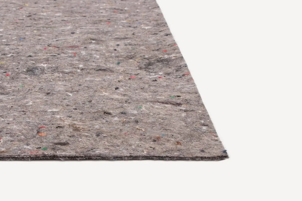 Close-up of a rectangular grey felt carpet underlay with multicolored fiber specks on a white background.