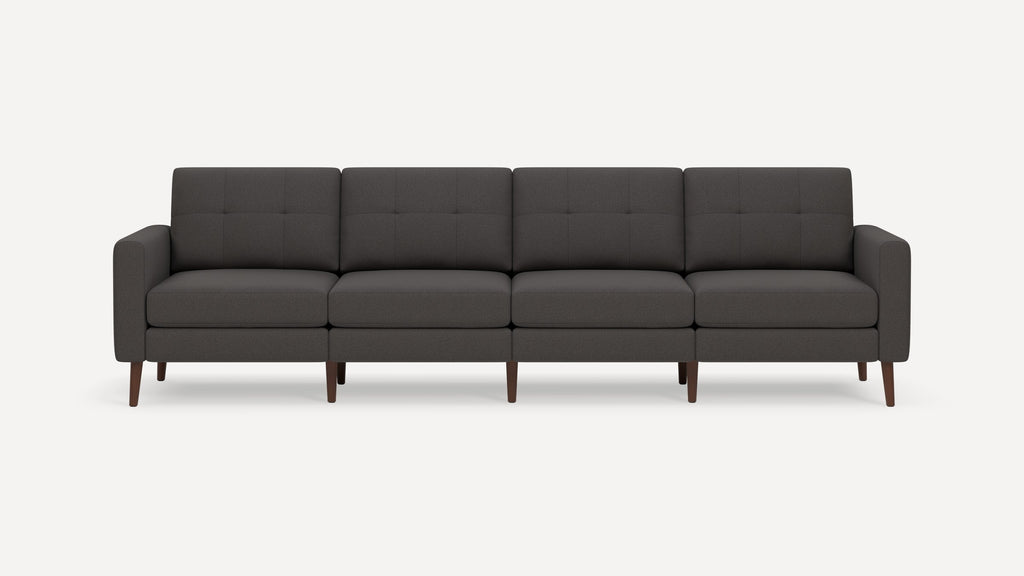 Dark gray four-seat sofa with tufted back cushions, padded arms, and wooden tapered legs on white background.