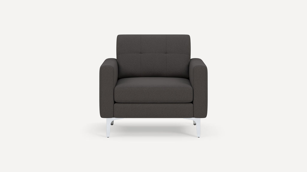 Front view of a modern dark gray fabric armchair with square tufted backrest and silver metal legs on a white background.