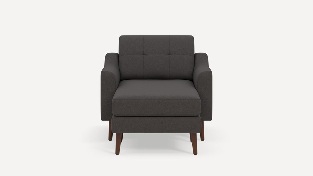 Dark gray upholstered armchair with plush cushions, straight armrests, tufted back, and wooden legs.