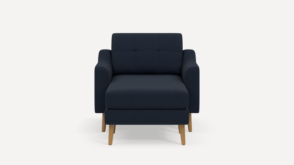 Front view of a modern dark navy blue armchair with wooden legs and a cushioned seat and backrest.