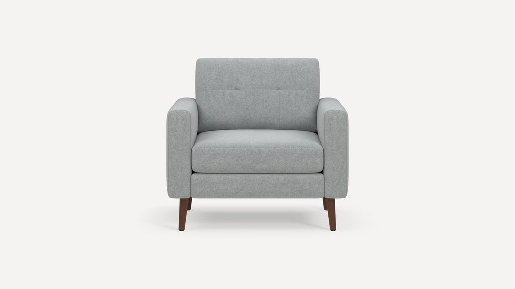 Front view of a modern gray fabric armchair with padded arms, tufted backrest, and wooden tapered legs.