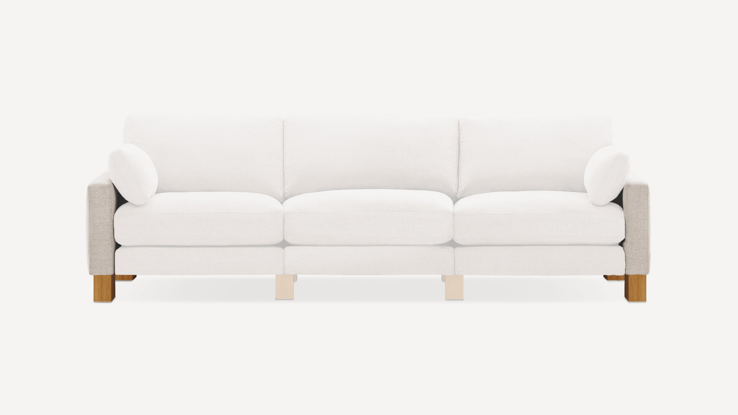 Modern three-seater sofa with light beige fabric upholstery, wooden legs, and matching cylindrical pillows on each armrest.