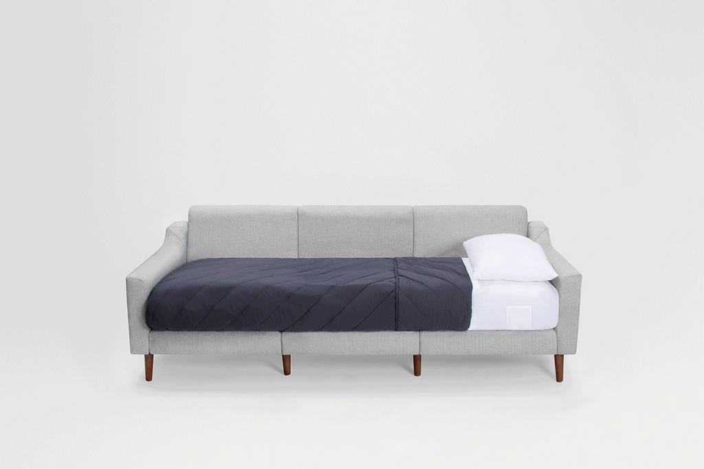 a gray sofa with a white pillow and a white pillow on it