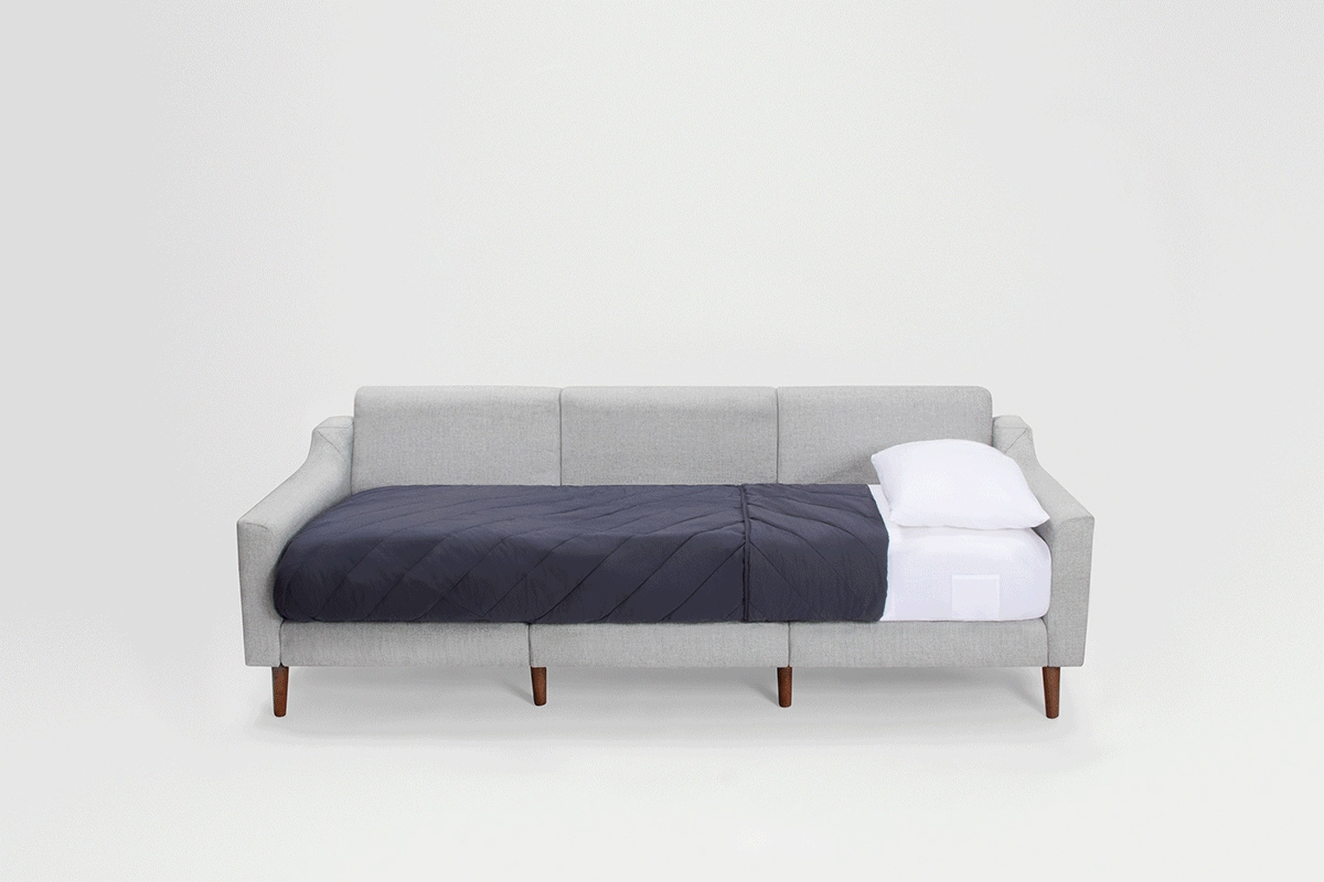 a gray sofa with a white pillow and a white pillow on it