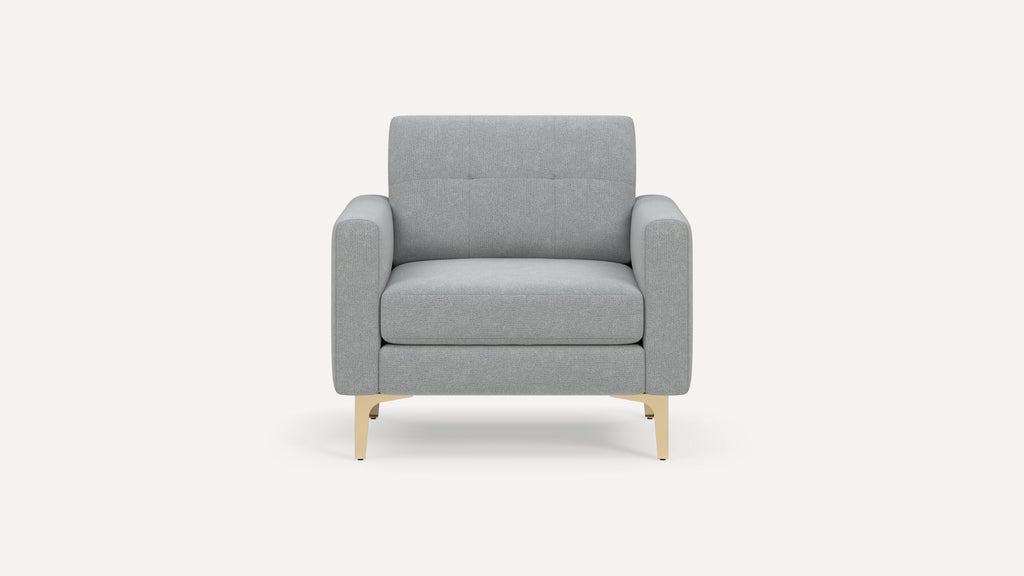 Front view of a modern light gray upholstered armchair with wide armrests and gold metal legs.