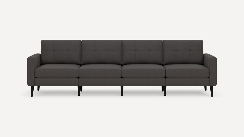 Modern dark gray four-seater sofa with tufted back cushions, slim armrests, and black tapered wooden legs.