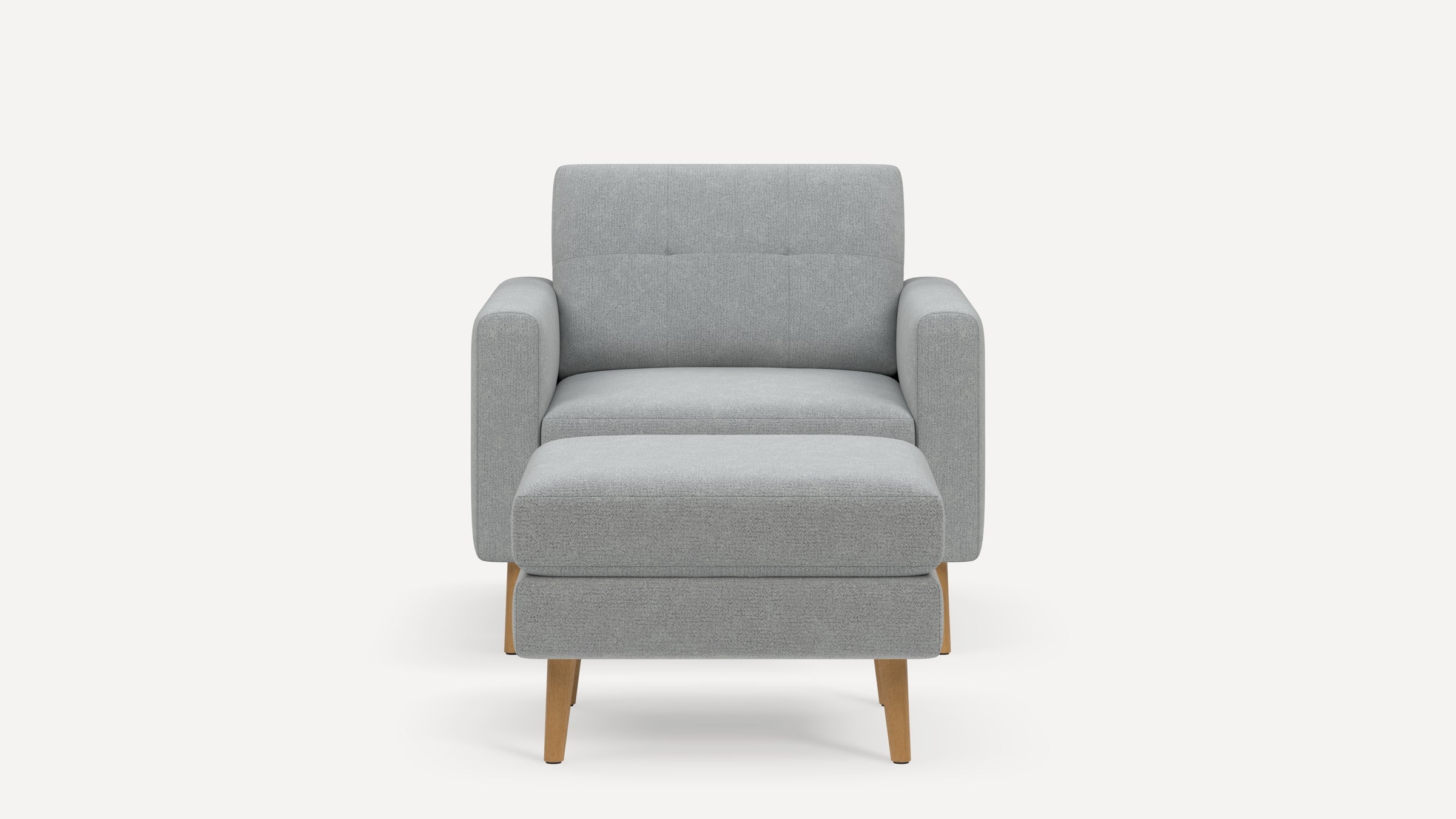 Front view of a modern light gray upholstered armchair with wooden legs and matching cushioned ottoman on a white background.