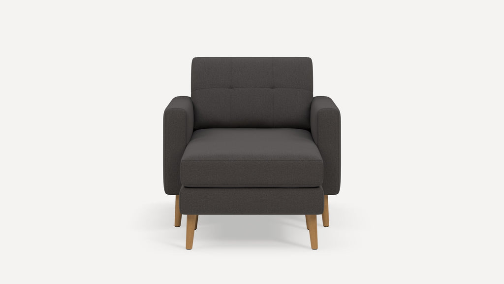 Front view of a modern dark gray upholstered armchair with wooden legs against a plain white background.