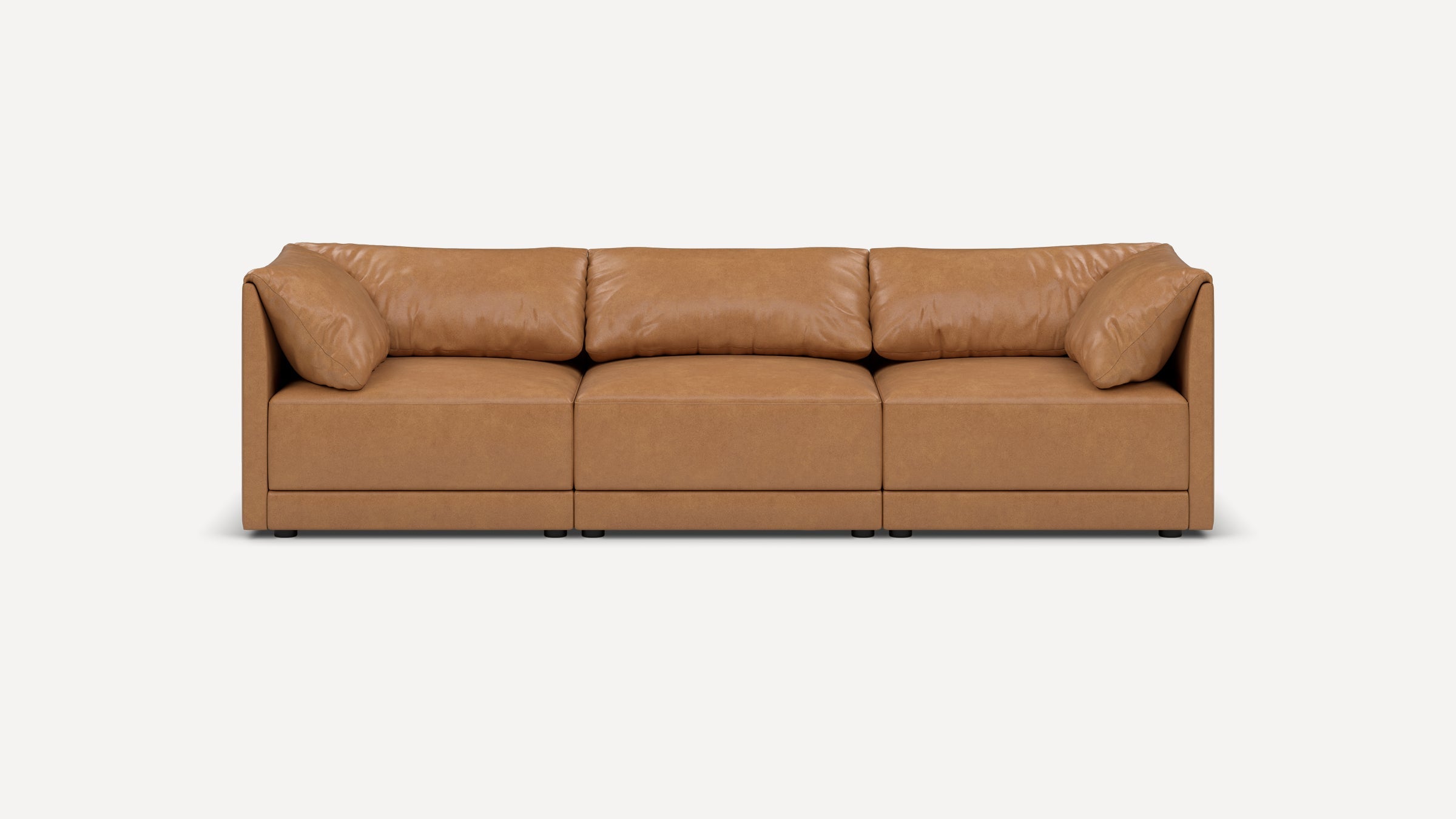 Modern three-seater sofa in light brown leather with plush cushions and clean, straight armrests, set against a white background.