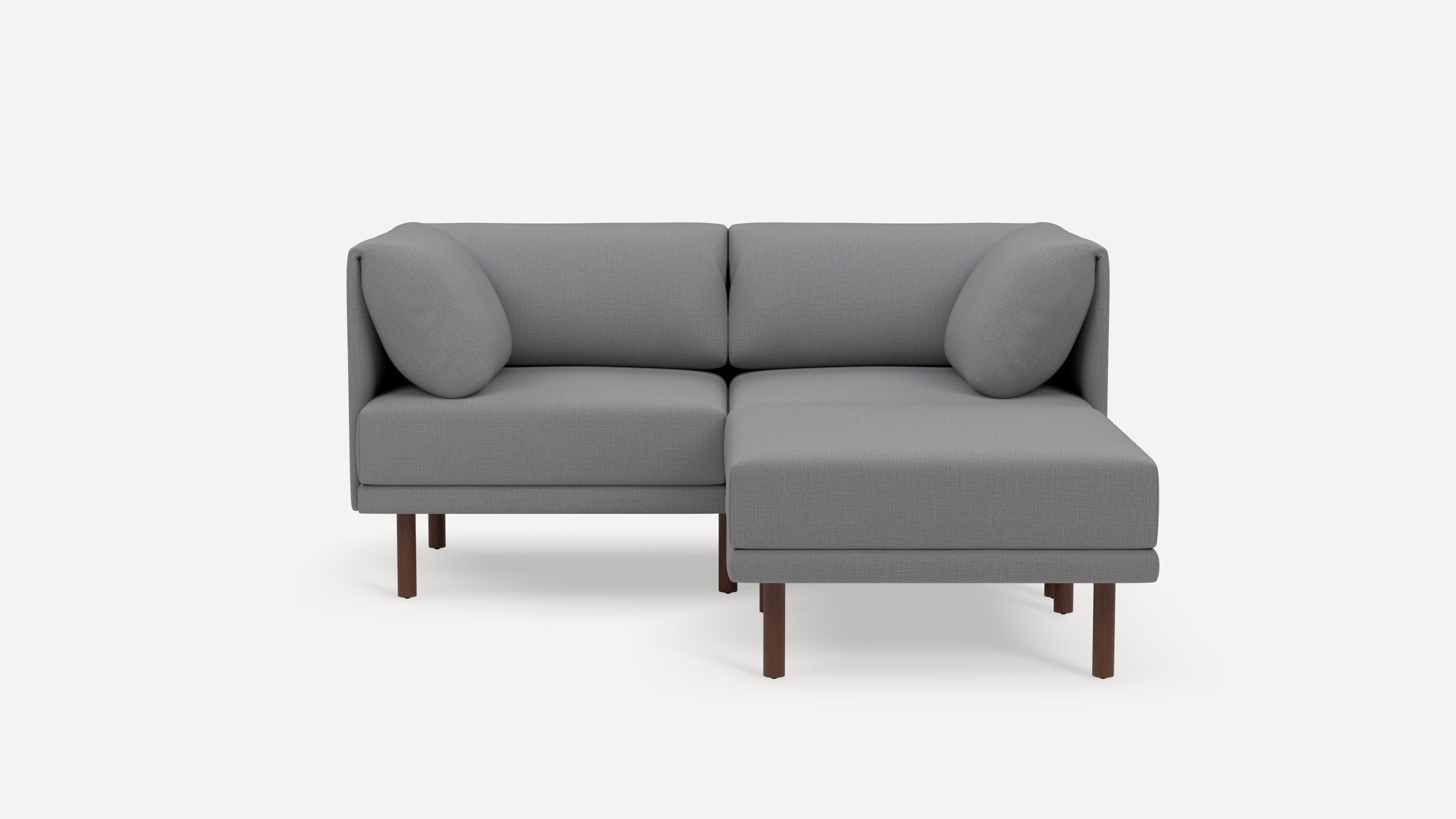 Modern gray L-shaped sectional sofa with wooden legs and rounded cushions on a white background.