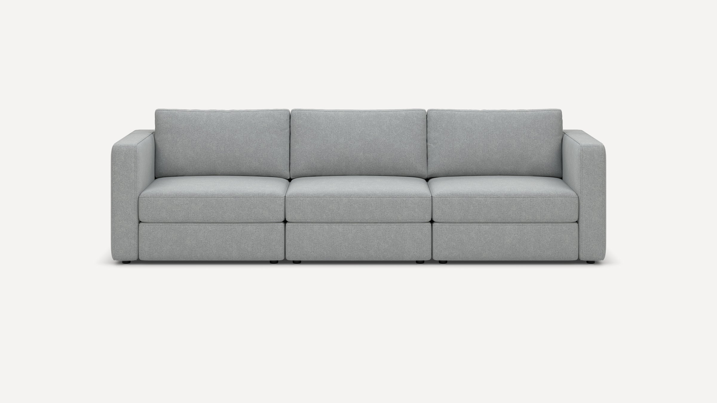 Modern three-seater sofa with light gray fabric upholstery, straight armrests, and thick cushioned seats and backrests.