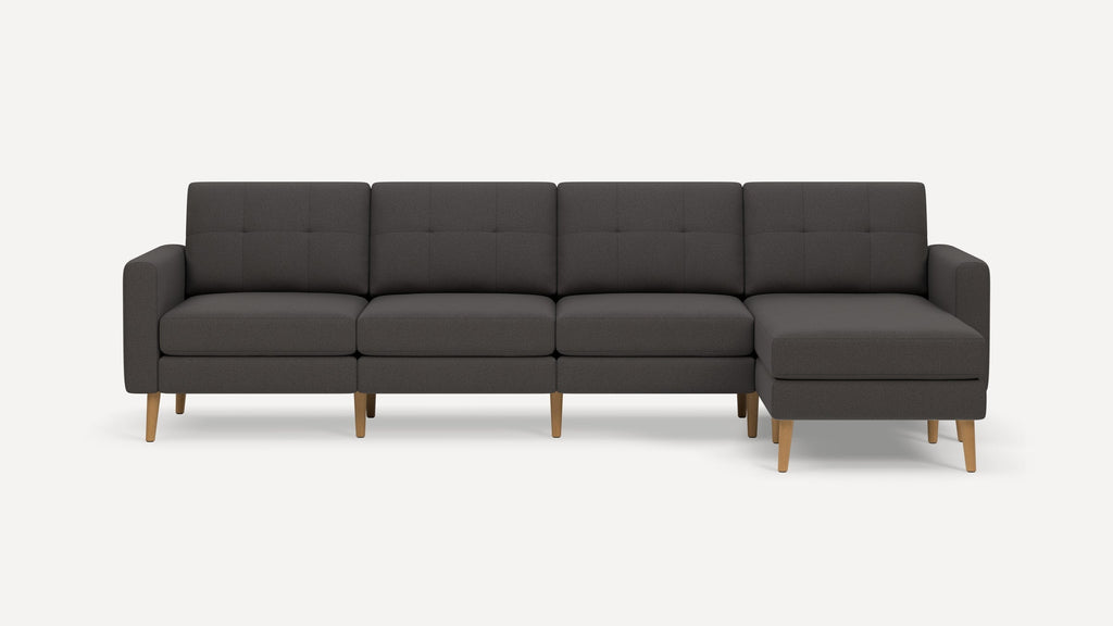 Modern dark gray sectional sofa with tufted cushions, wooden legs, and a right-side chaise lounge on a plain white background.