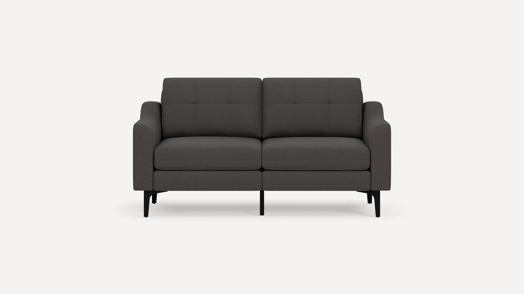 Dark gray modern two-seater sofa with tufted backrest, cushioned armrests, and black angled legs on a plain background.